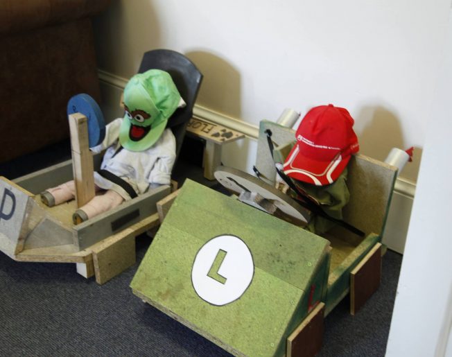 dummies set up in wooden race cars